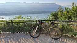 Un VTT posé contre la barrièrre d'un belvédère qui surplombe le lac du Bourget